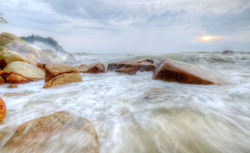 Waves splashing in sea against sky