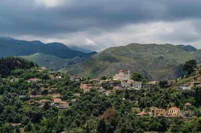 Houses in town against cloudy sky