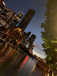 Illuminated buildings in city against sky