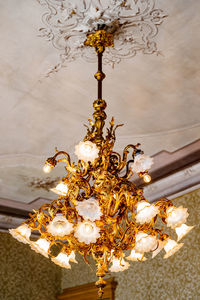 Low angle view of illuminated chandelier hanging on ceiling