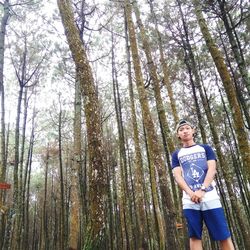 Portrait of young man standing in forest