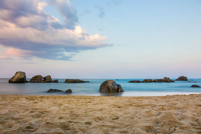 Scenic view of rocks on beach against sky