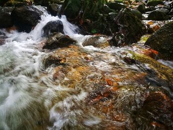 View of stream flowing through rocks