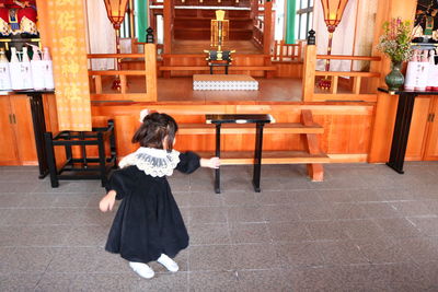 Rear view of woman walking in front of temple