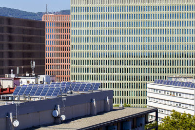 Solar panels on the roof to save energy. the facades of modern office buildings are visible behind.