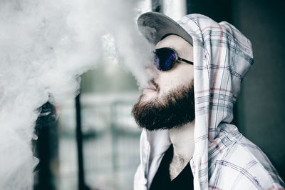 Close-up of young man smoking outdoors