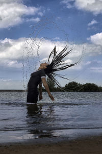 Woman at beach against sky