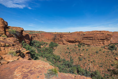 Rock formations on landscape against blue sky