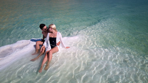 Aerial image of beautiful models passionate couple kissing and embracing in the seawater. dead sea 