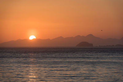 The sun falling behind mountains, a spectacular sunset at north coast, trotternish, isle of skye