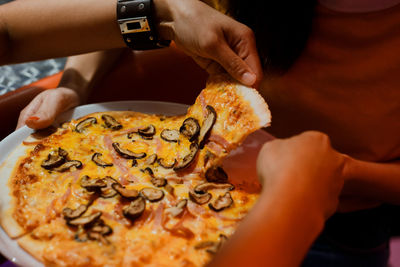 Close-up of hand holding pizza