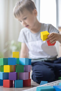 Boy playing with toy blocks at home