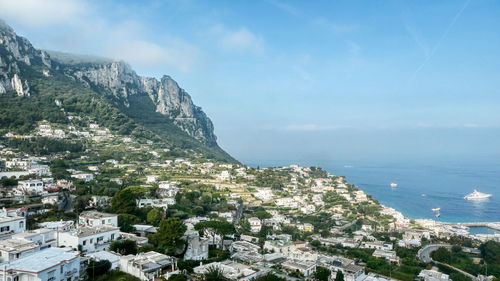 High angle view of townscape by sea against sky