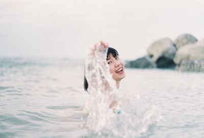 Portrait of young woman swimming in sea