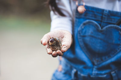 Midsection of girl holding insect