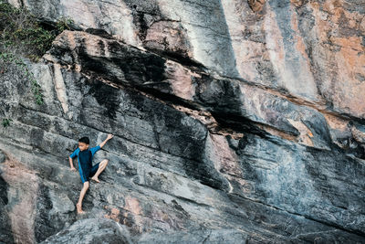 Full length of boy climbing on rock