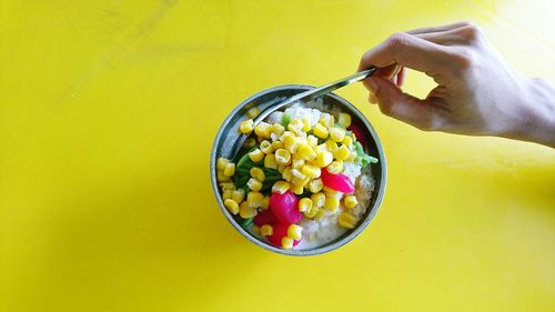 High angle view of hand holding fruits in bowl