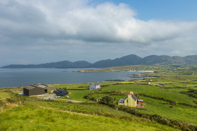 Houses on field by mountains against sky