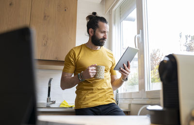 Young man using mobile phone at home