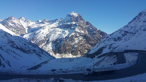 Scenic view of snowcapped mountains against cloudy sky