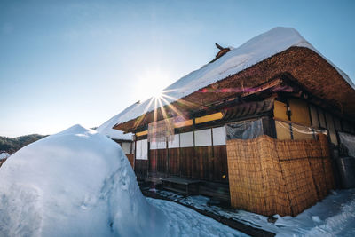 Houses on snow covered landscape against sky