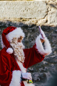 Side view of man in santa claus costume gesturing