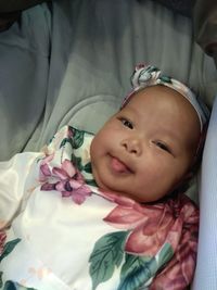 Portrait of cute baby girl lying on bed