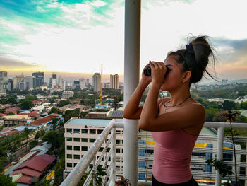 Midsection of woman standing against buildings in city