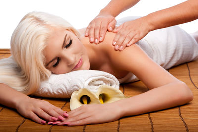 Young woman receiving back massage against white background