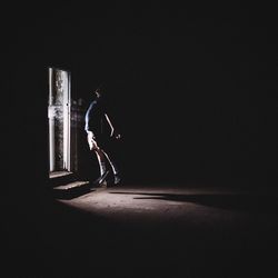 Full length of man standing mid air in the dark