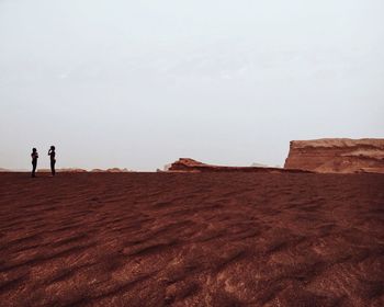 Silhouette man standing on landscape against clear sky