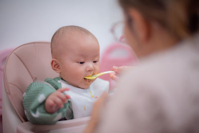 Close-up of boy blowing bubbles at home