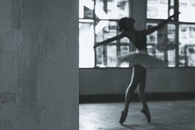 Side view of woman standing by window