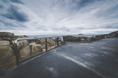 Footpath by sea against sky