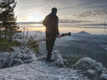 Hiker admiring the stunning misty mountain range, sunny morning. epic travel in a wilderness,