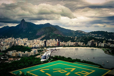 View of cityscape against cloudy sky