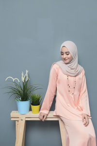 Young woman using smart phone against white background