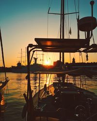 Silhouette boats sailing in sea against sky during sunset