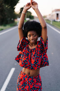 Portrait of a young woman standing on road