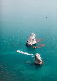 Two rocks stick out of the water in the middle of the turquoise sea. scenic ocean view. 
