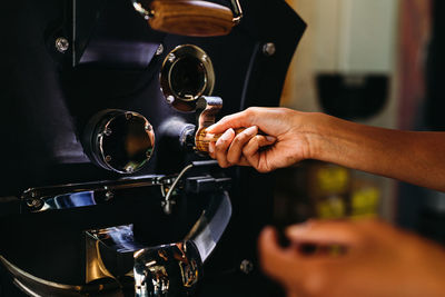 Cropped image of woman using coffee machine