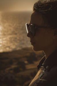 Side view of young woman standing at beach