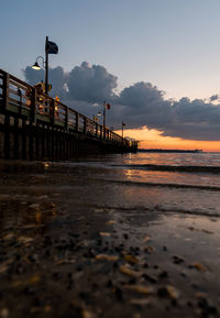 Pier over sea against sky during sunset