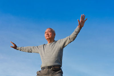 Low angle view of woman against blue sky