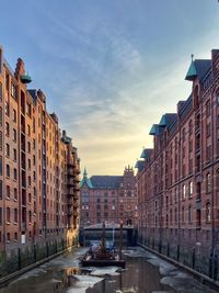 Buildings in city against sky during sunset