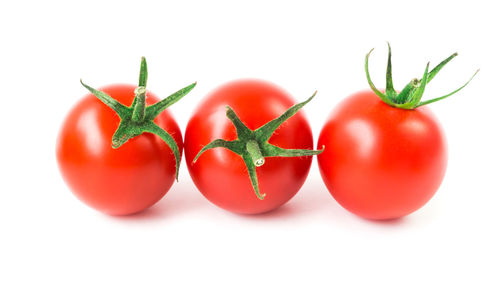 Close-up of tomatoes over white background
