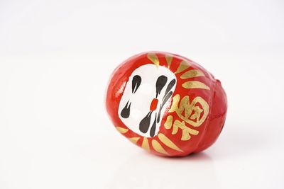 Close-up of red bell over white background