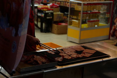 High angle view of hand preparing meat for sale in store