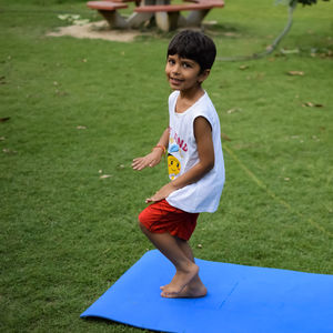 Asian smart kid doing yoga pose in the society park outdoor, children's yoga pose. the little boy