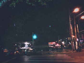 Empty road along illuminated street lights at night